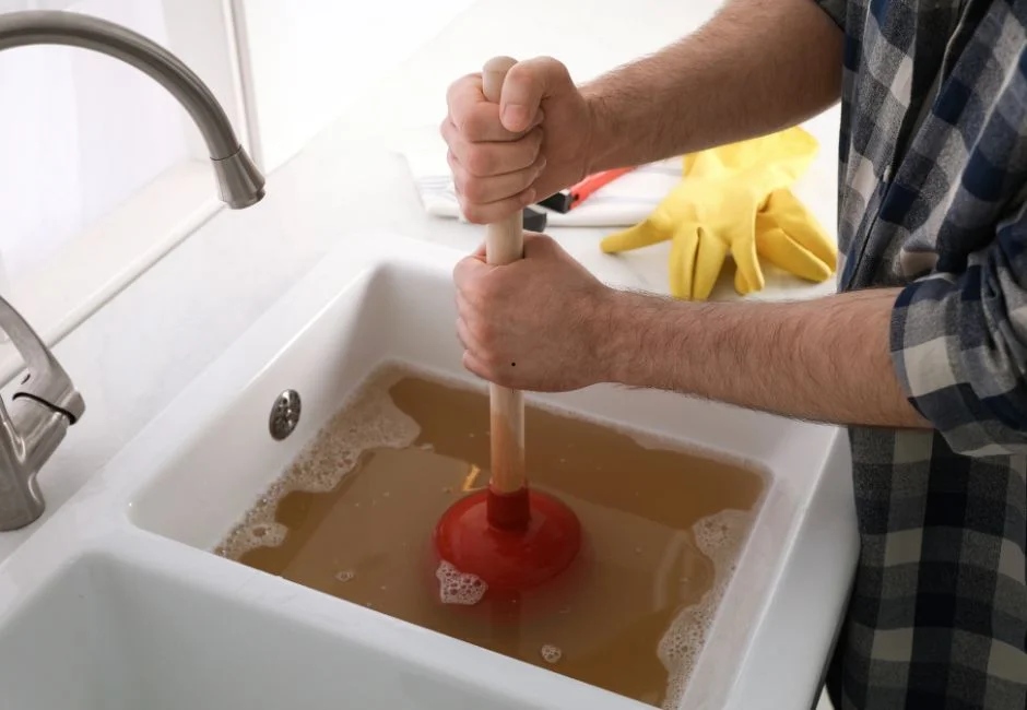 Plunger being used on a clogged sink drain